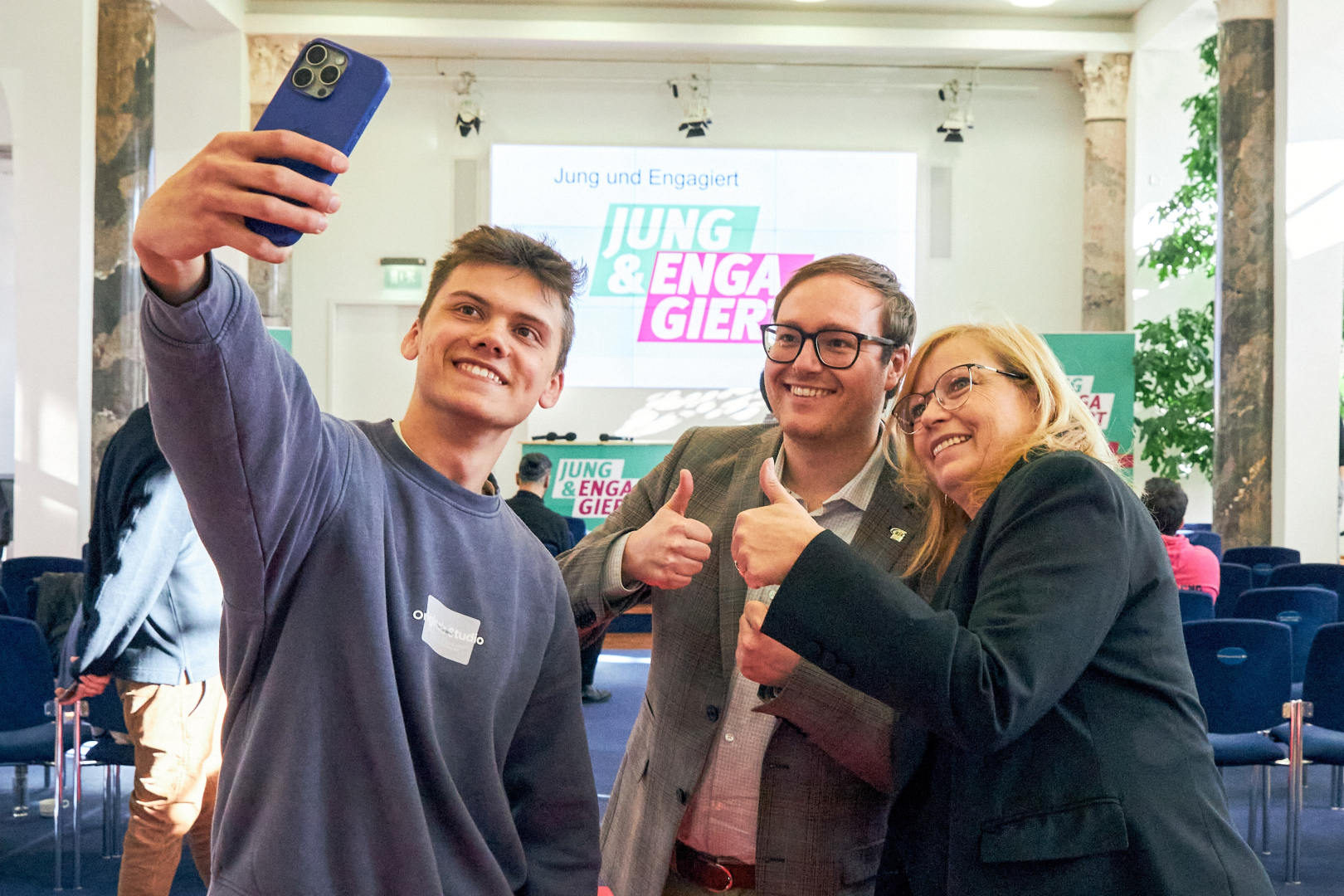 Junger Mensch macht Selfie mit zwei Politiker*innen auf Jung & Engagiert-Veranstaltung